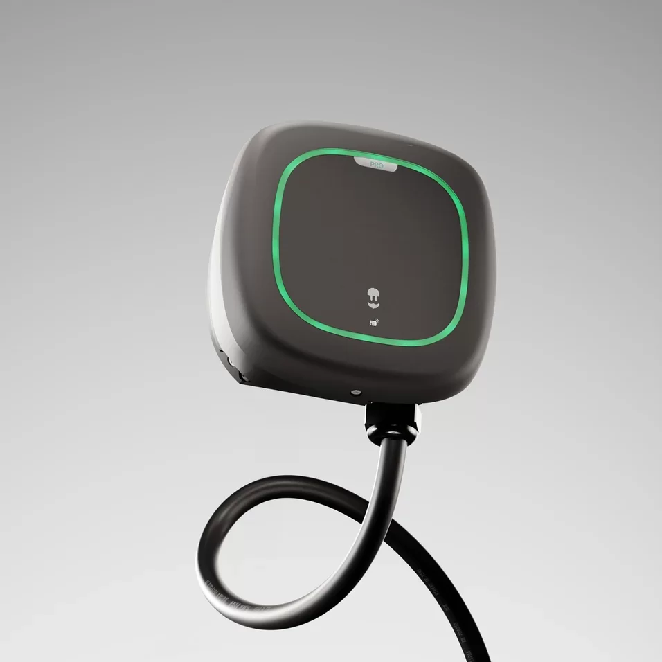 Svart laddbox med rundade hörn, grön ljusram på fronten och svart kabel mot grå bakgrund.